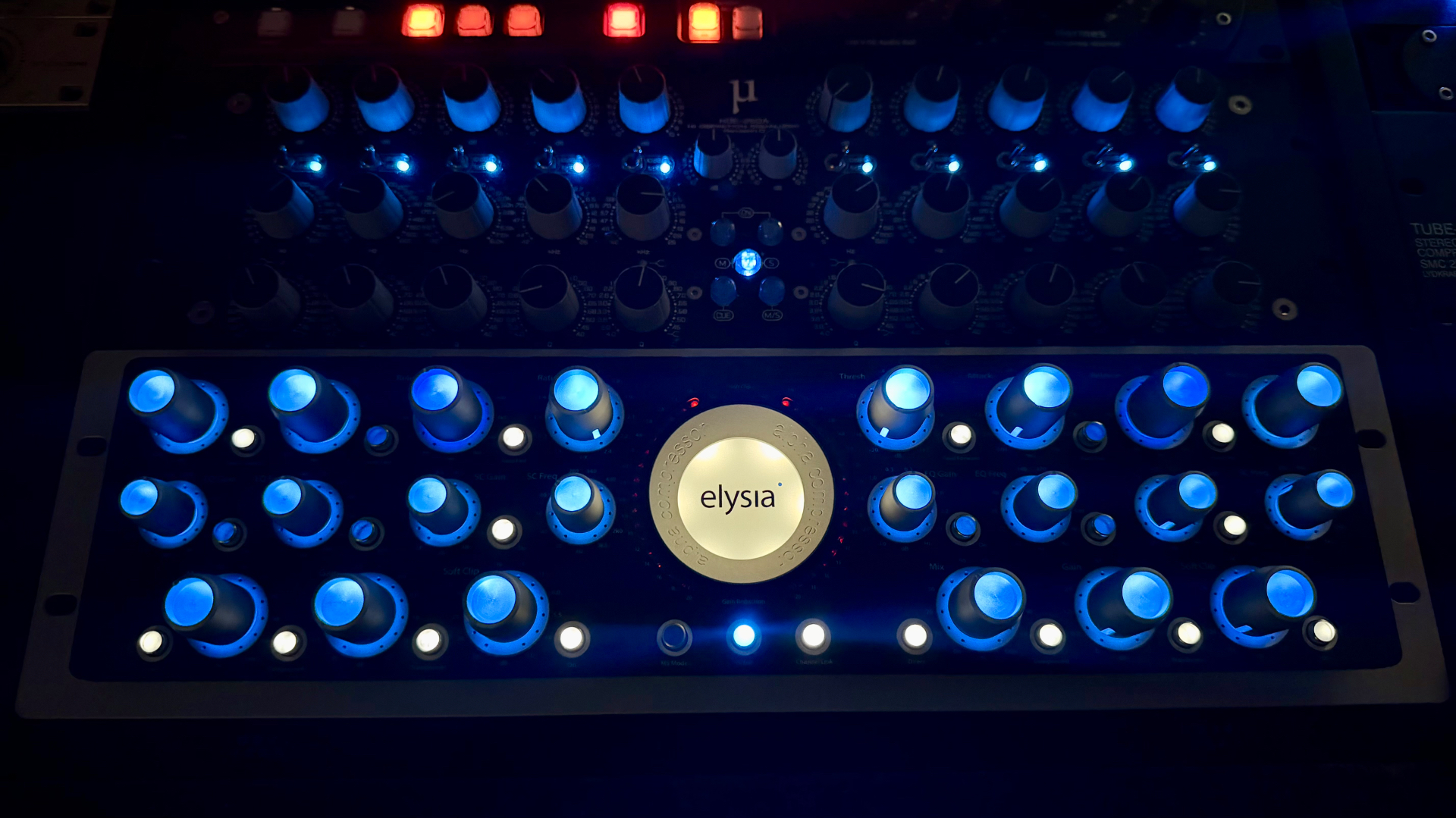 Elysia Alpha mastering compressor and analog rack glowing blue in the mastering room